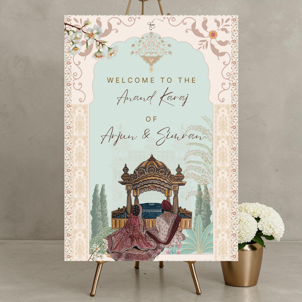 Anand Karaj Sikh wedding welcome sign on a gold easel showing a bride in burgundy lehenga and groom in red dastar seated beneath a golden gurudwara canopy inside an ornate Mughal arch with folk-art floral border and Ik Onkar at top