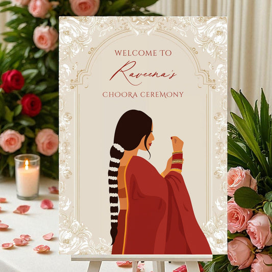 Close-up of Choora ceremony sign showing illustrated Punjabi bride in red suit holding choora bangles with personalised bride name in script font on ivory background