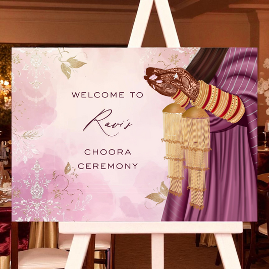Decorative sign for a Ravi's Choora Ceremony event with floral design and traditional attire on an easel.