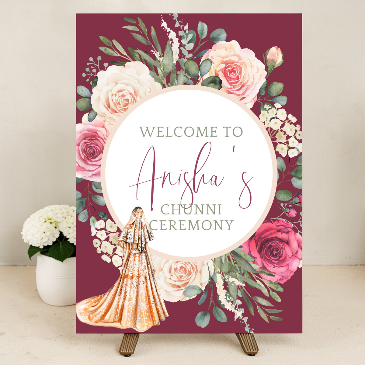 Personalised Indian wedding welcome sign on easel at Chunni ceremony entrance decorated with pink and white floral arrangements