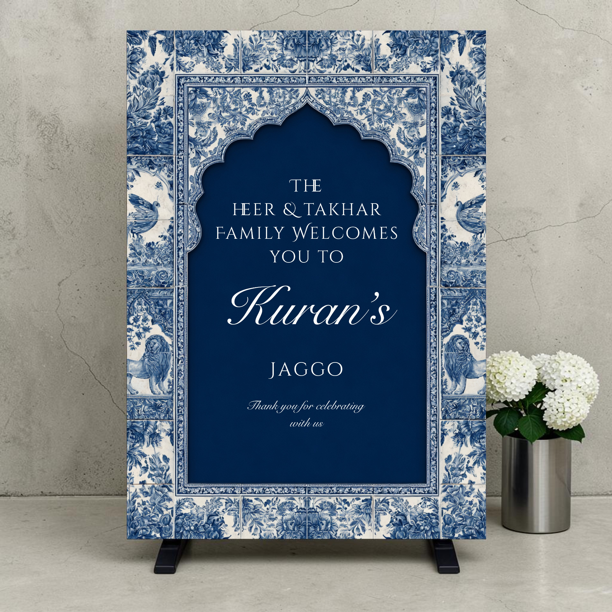 Personalised Jaggo night welcome sign printed on 3mm foamex. Navy blue Mughal arch on intricate blue and white floral tile border with lion and bird motifs. Custom two-family names, bride or groom name in script and Thank You for Celebrating With Us. A1 or A2. By Krafty Kaur.