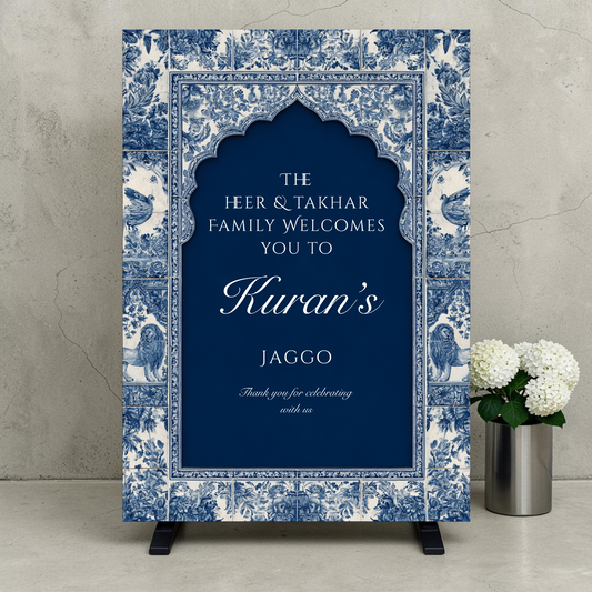 Personalised Jaggo night welcome sign printed on 3mm foamex. Navy blue Mughal arch on intricate blue and white floral tile border with lion and bird motifs. Custom two-family names, bride or groom name in script and Thank You for Celebrating With Us. A1 or A2. By Krafty Kaur.