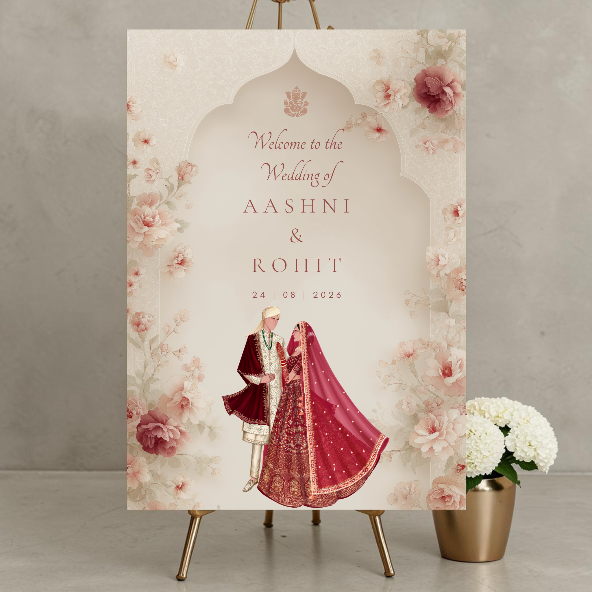 Personalised Hindu wedding welcome sign on 3mm foamex displayed on gold easel featuring Ganesh symbol, illustrated bride in crimson red lehenga and groom in red sherwani within soft cream Mughal arch surrounded by blush and mauve watercolour peonies