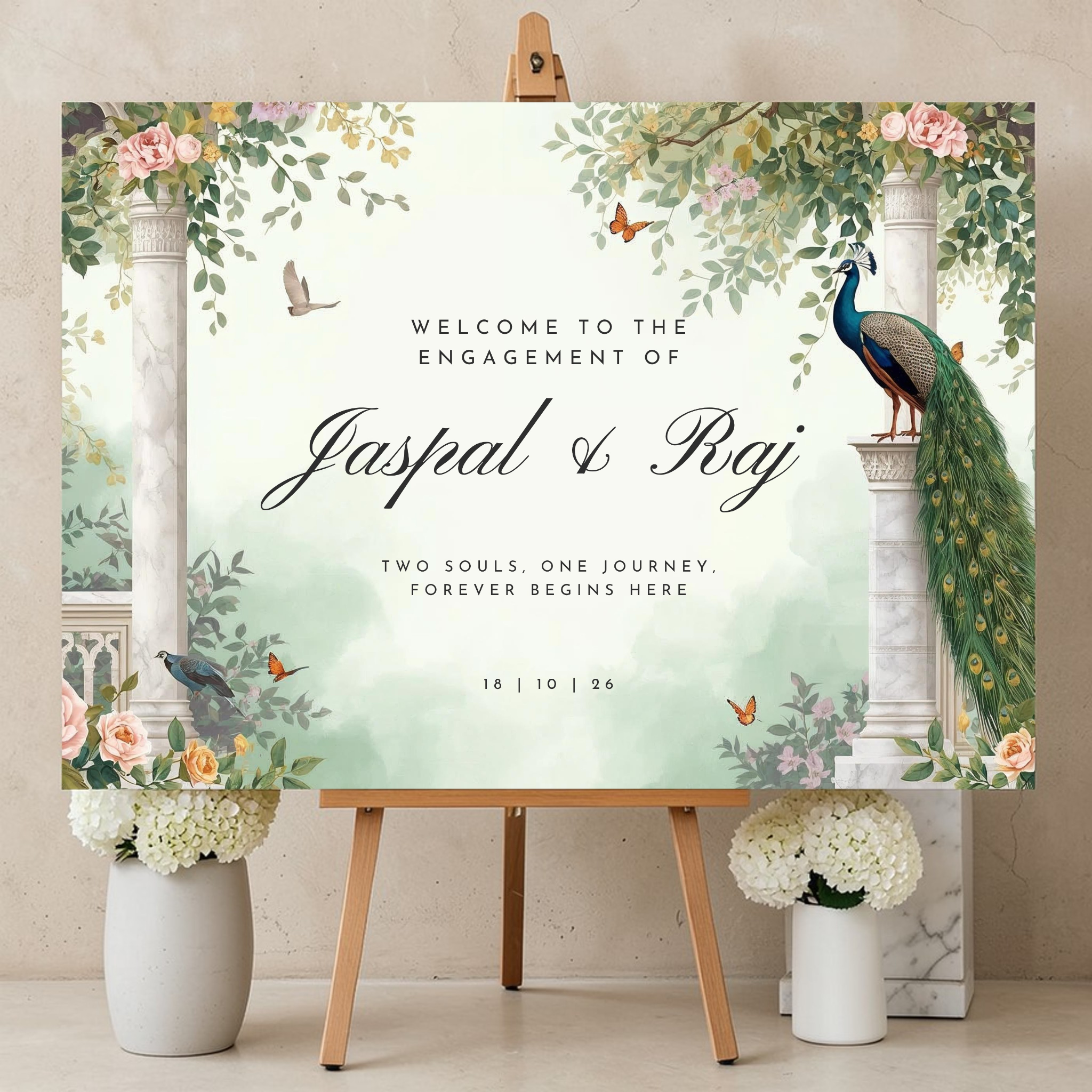 Indian engagement welcome sign on an easel showing a peacock on a marble column framed by botanical arches, butterflies and sage watercolour, reading "Welcome to the Engagement of Jaspal and Raj"