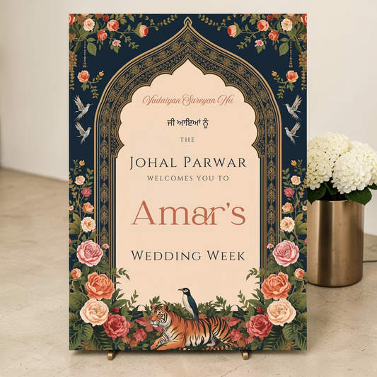 Personalised Indian wedding week welcome sign printed on 3mm foamex, featuring Mughal arch in navy and gold, botanical florals, illustrated tiger and peacock, displayed on a brass easel