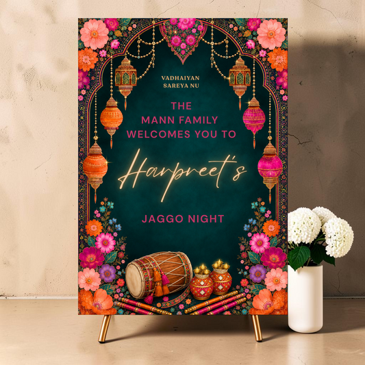 Personalised Jaggo night welcome sign printed on 3mm foamex. Dark teal background with ornate Mughal arch, hanging gold orange and pink lanterns, vibrant multicolour florals, dhol drum and matka pots. Vadhaiyan Sareya Nu greeting, custom family name and bride or groom name in gold neon script. A1 or A2. By Krafty Kaur.
