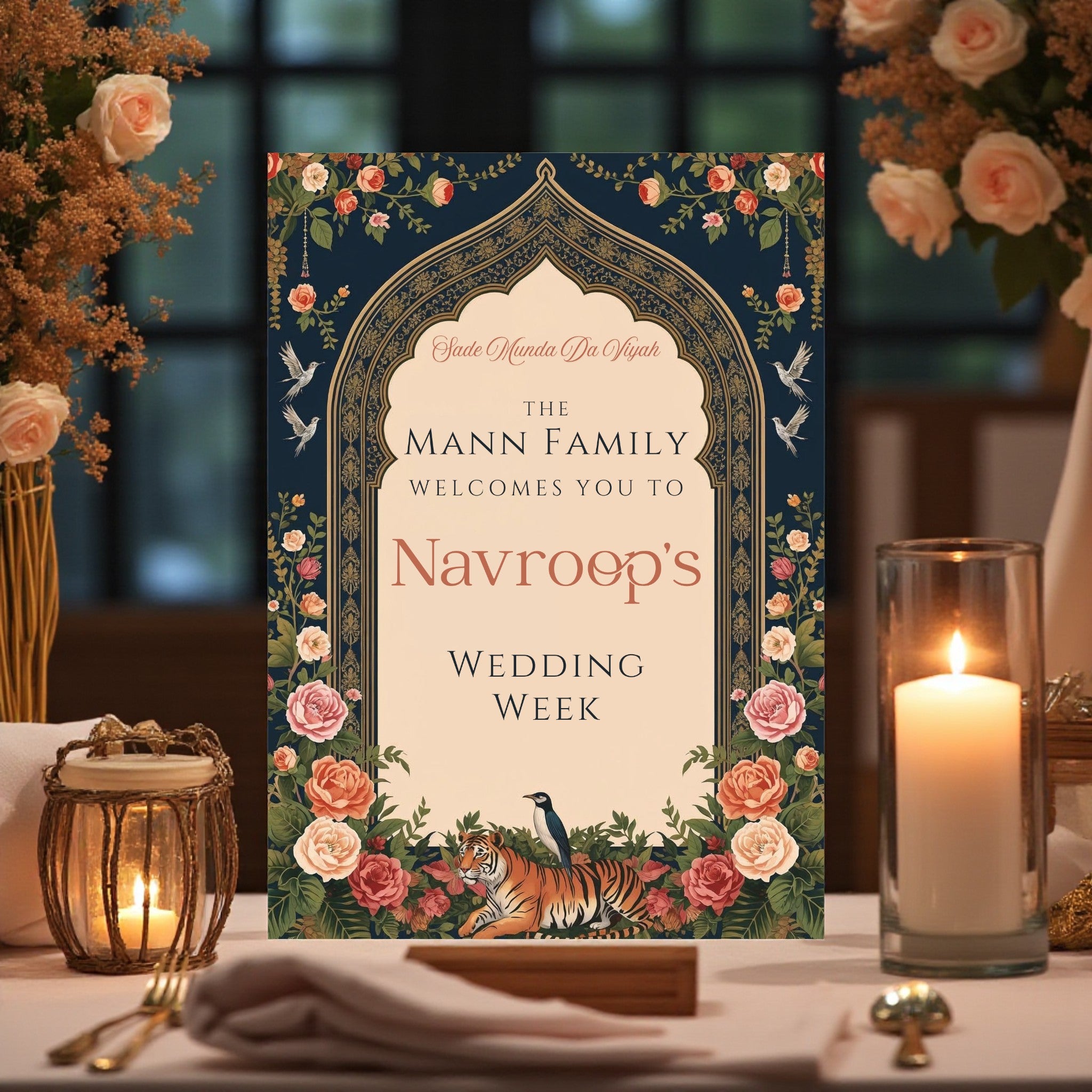 Close-up of personalised wedding week sign showing family name and bride name in serif and script fonts inside a Mughal gold arch with Gurmukhi script detail