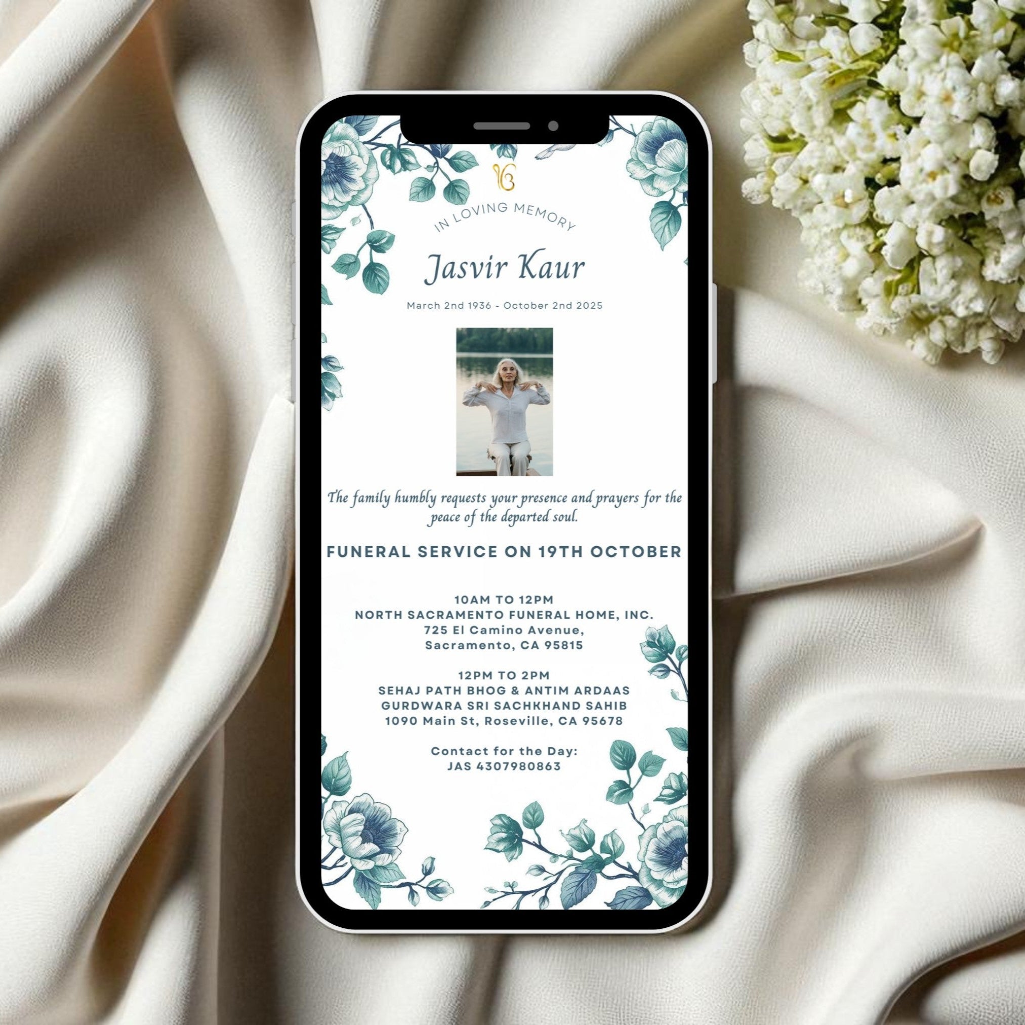 Phone displaying funeral invitation with floral design on a white fabric background