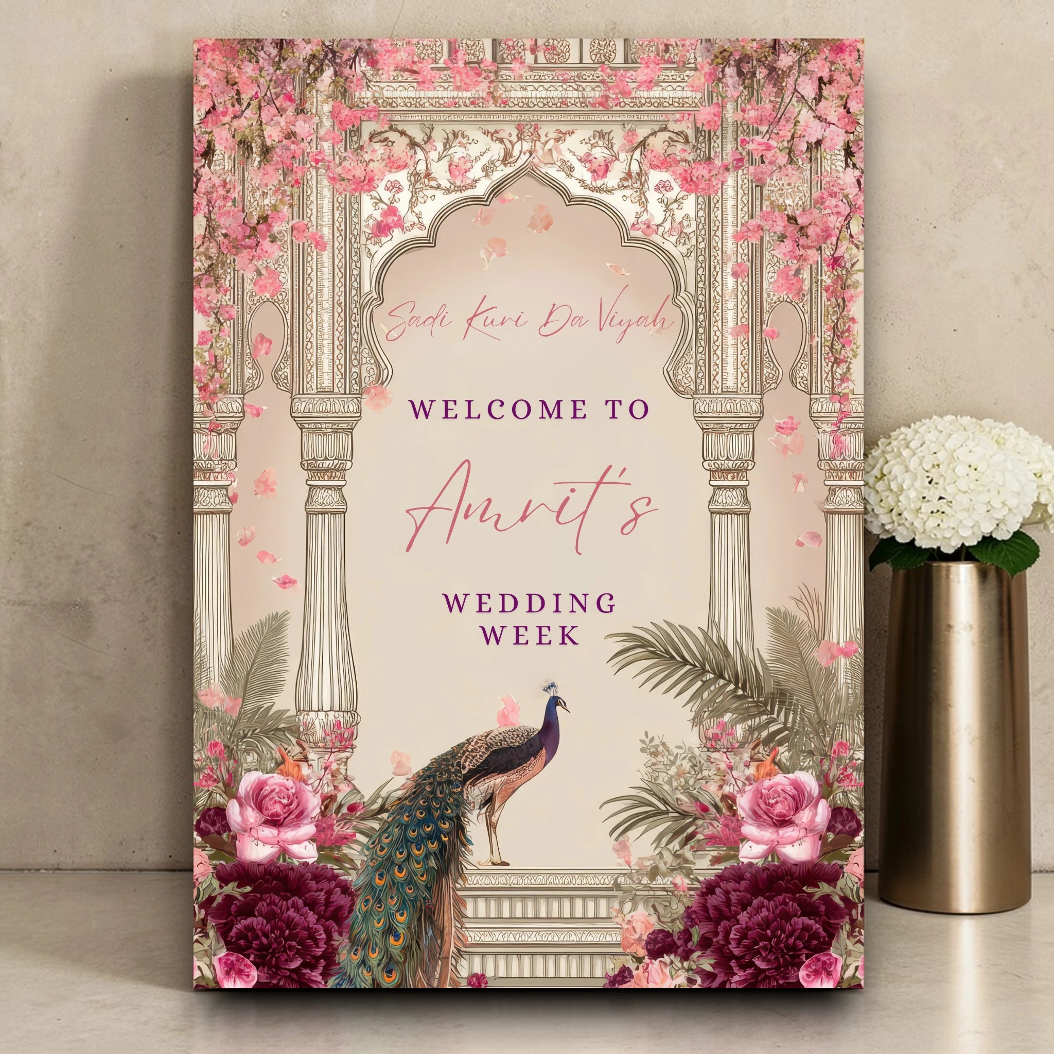 Personalised Punjabi wedding week welcome sign printed on 3mm foamex featuring Sadi Kuri Da Viyah script, regal peacock illustration and pink cherry blossom Mughal arch with burgundy peonies