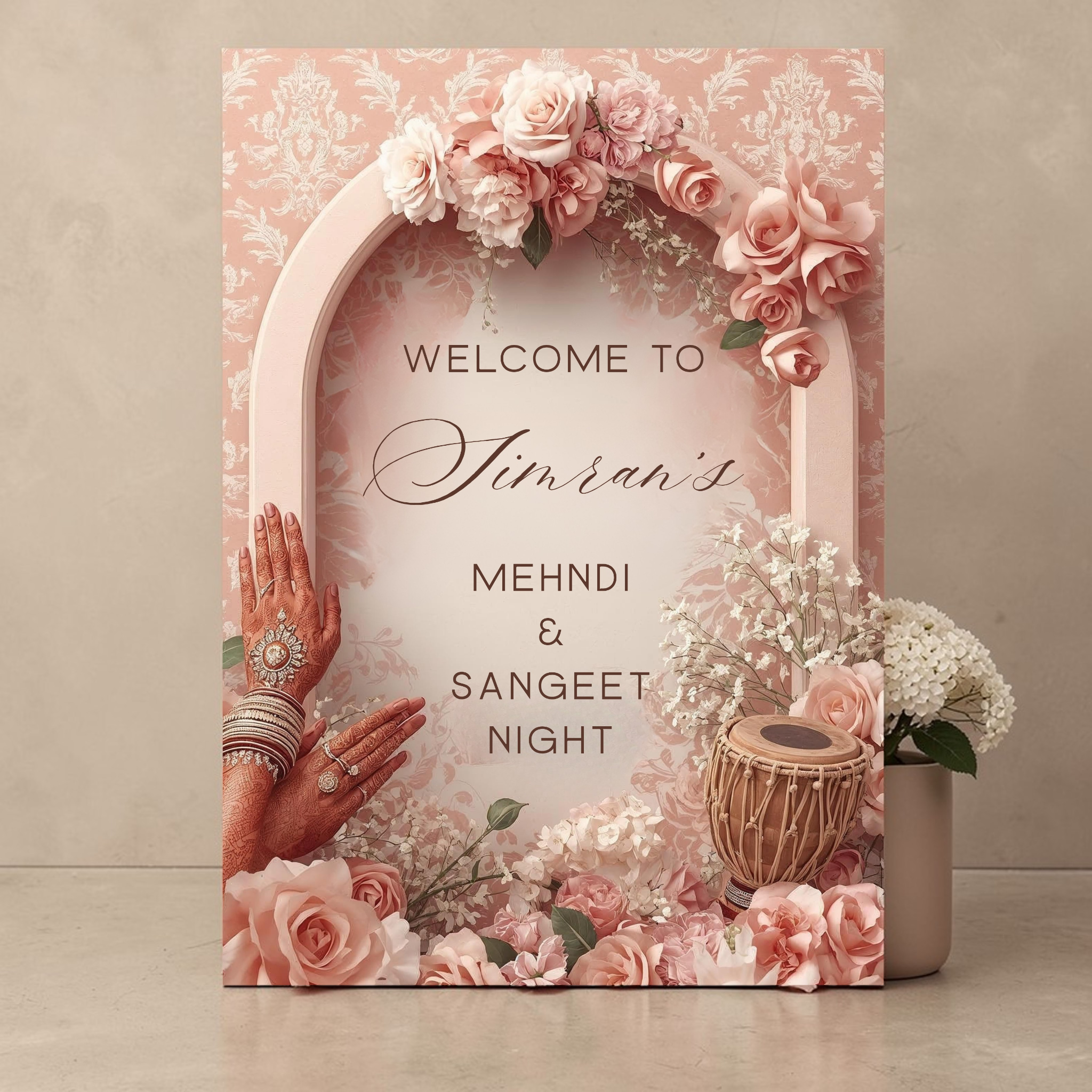 Personalised Mehndi and Sangeet Night welcome sign printed on 
3mm Foamex featuring blush rose arch with henna decorated hands 
dhol drum cascading pink roses and damask background custom name 
Simran in calligraphy script portrait A1 format leaning against 
neutral wall with white flowers