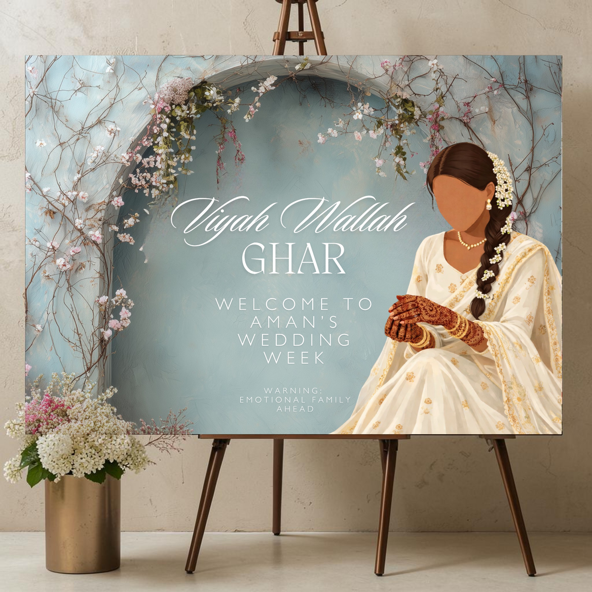 Personalised Punjabi bride wedding week welcome sign printed on 3mm foamex. Illustrated Indian bride in white suit with mehndi hands and pearl accessories beneath a blue floral arch with cherry blossoms. Text reads Viyah Wallah Ghar, custom bride's name, Warning Emotional Family Ahead. A1 or A2. By Krafty Kaur.